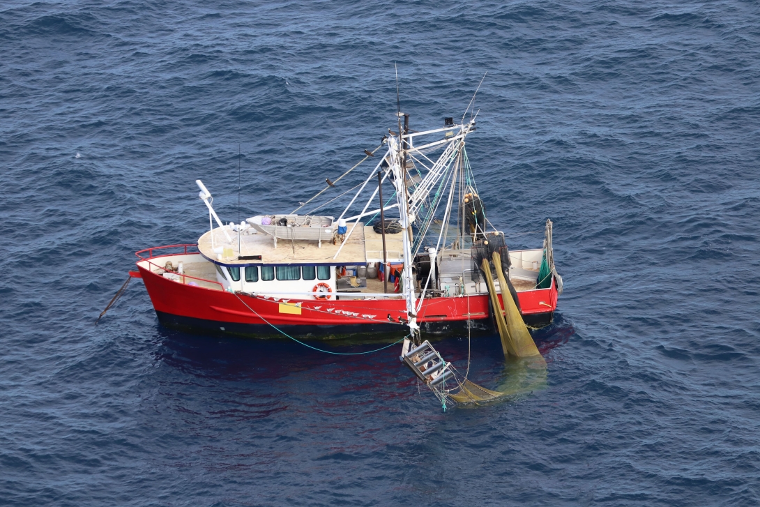 This photo shows a trawl vessel on the water. The nets are not fully deployed. 